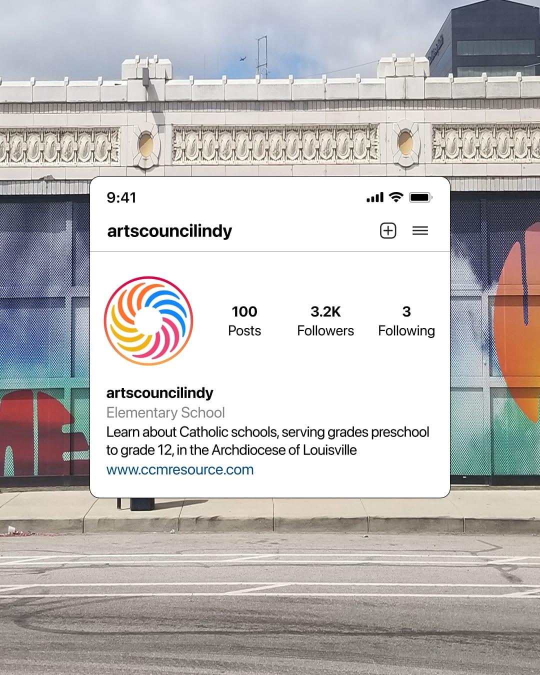 IndyArts Instagram profile shown on a phone screen over a photo of the mural-wrapped storefront