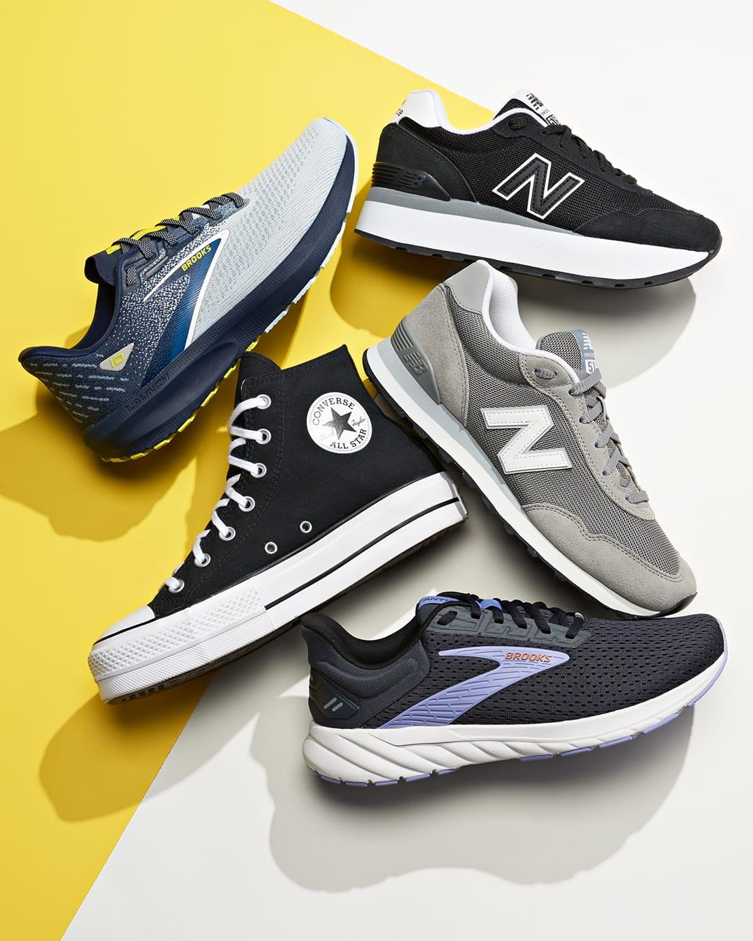 Product photo of five sneakers from Brooks, New Balance and Converse arranged on a yellow and white background
