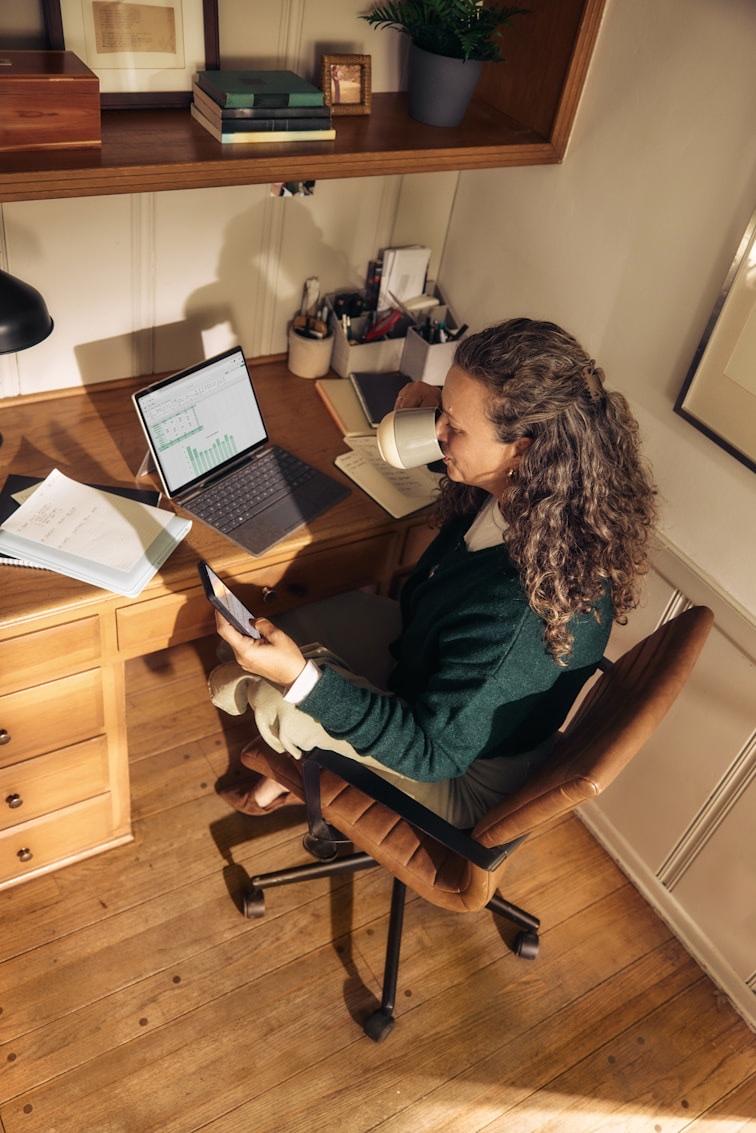 A woman working through notes at her desk