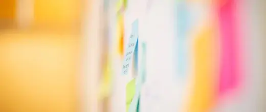 Sticky notes on a wall from a planning session, softly out of focus