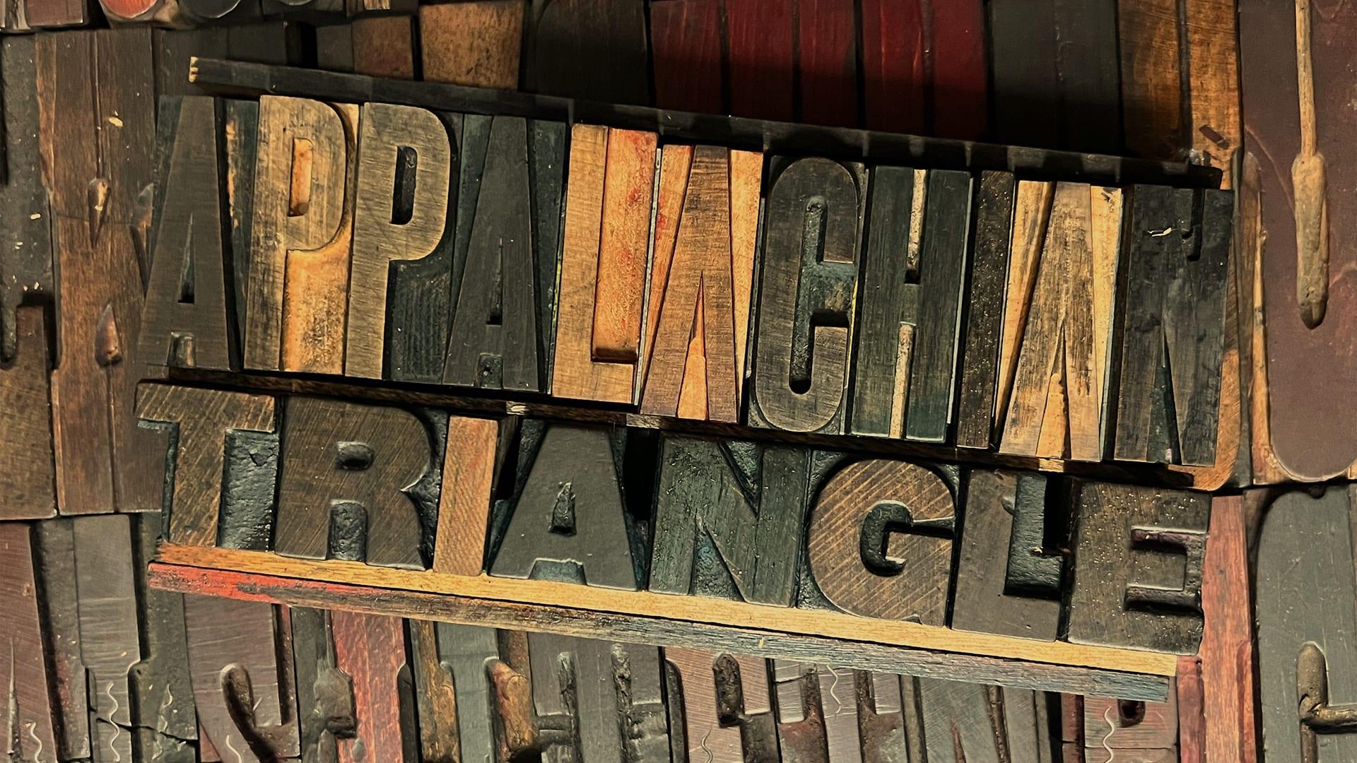 Weathered wooden letterpress type spelling Appalachian Triangle