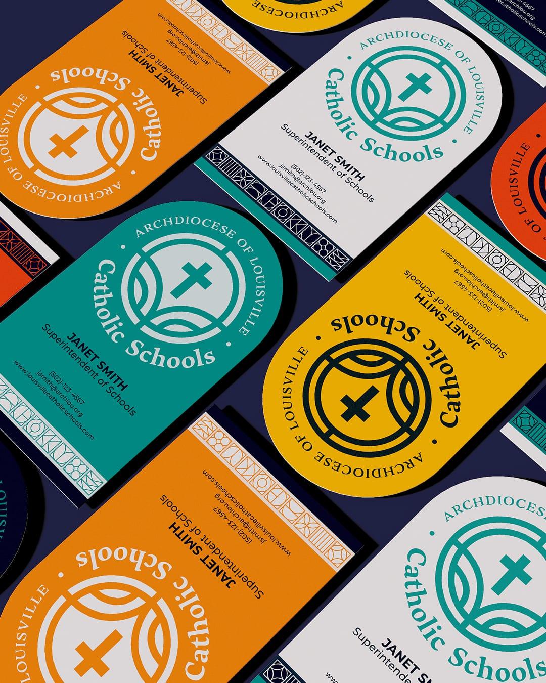 Colorful staff ID badges in orange, teal, yellow and white carrying the Catholic Schools logo