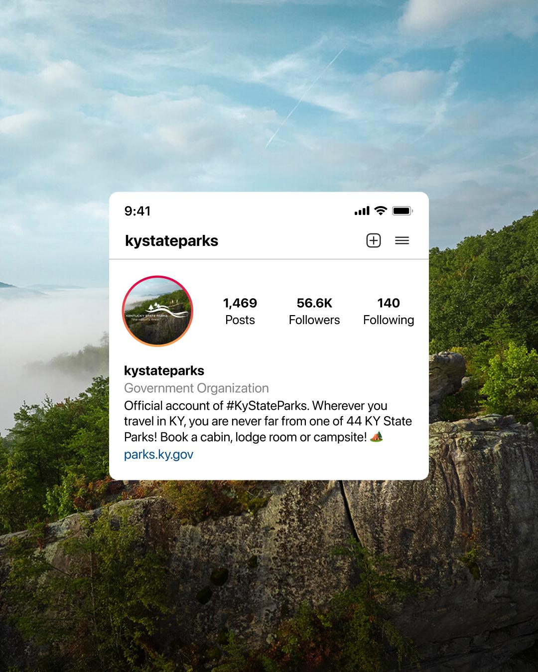 The kystateparks Instagram profile on a phone screen, set over a forested cliff above a misty valley