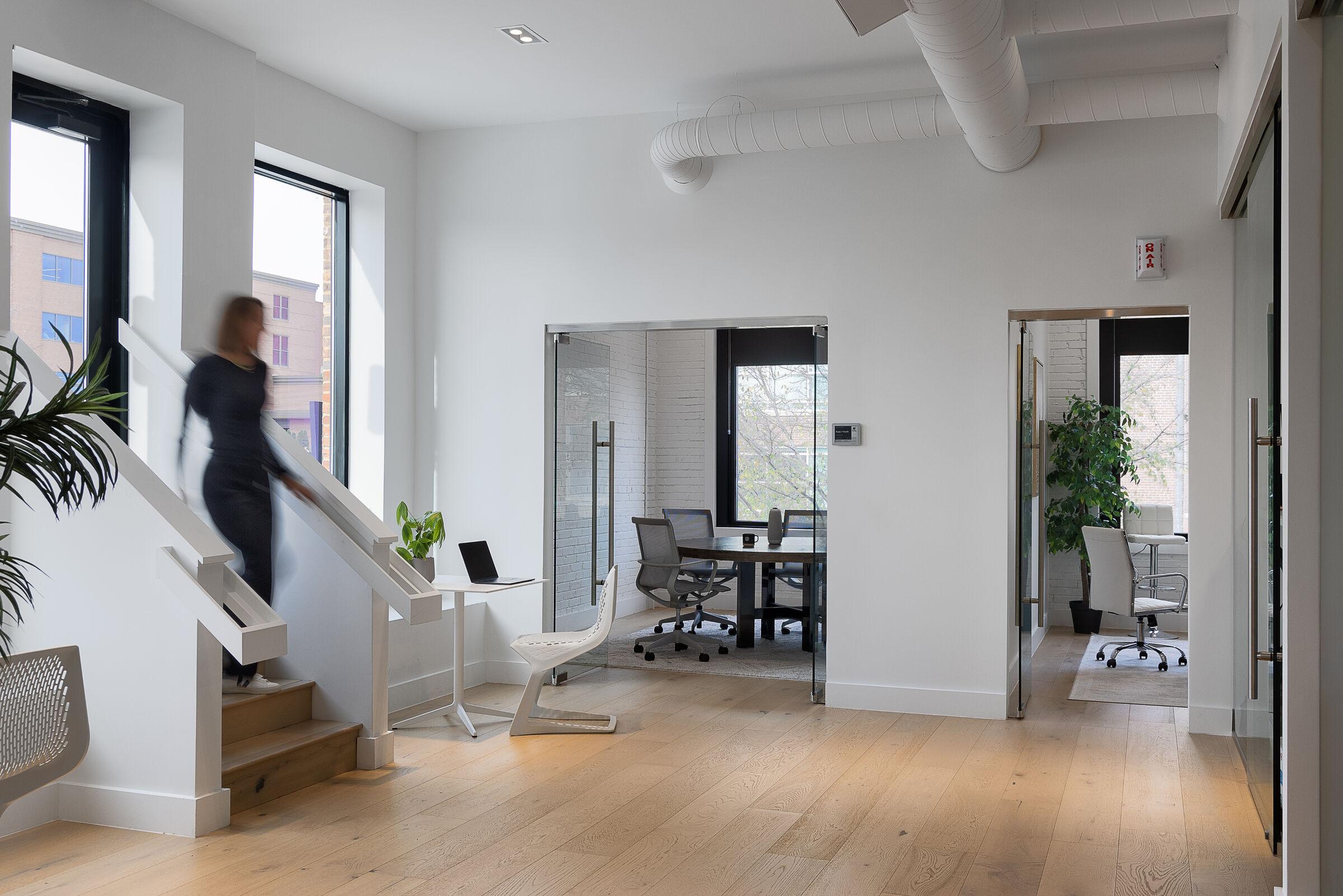 The RedTag studio: a team member on the stairs, meeting rooms beyond